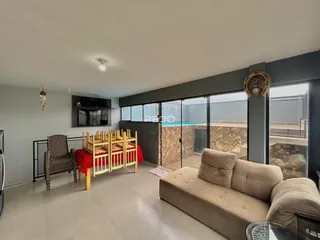 Sala de estar com sofá e área de jantar em um imóvel em Lajeado.
