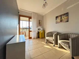 Sala de estar com piso de cerâmica e móveis de estofados.