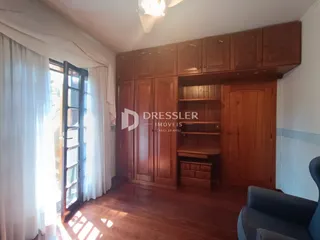 Quarto com armários em madeira e piso de madeira.