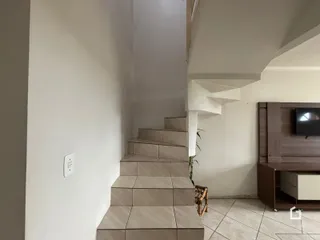 Hall de entrada com escadaria e móveis de madeira.