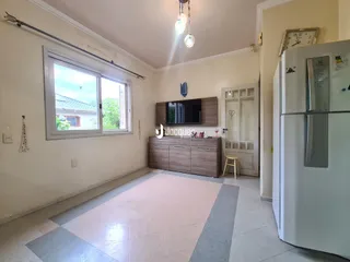Sala de estar com grande janela e piso de cerâmica clara.