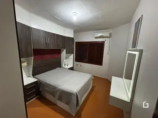 Quarto com armários embutidos e cama no interior de uma residência.