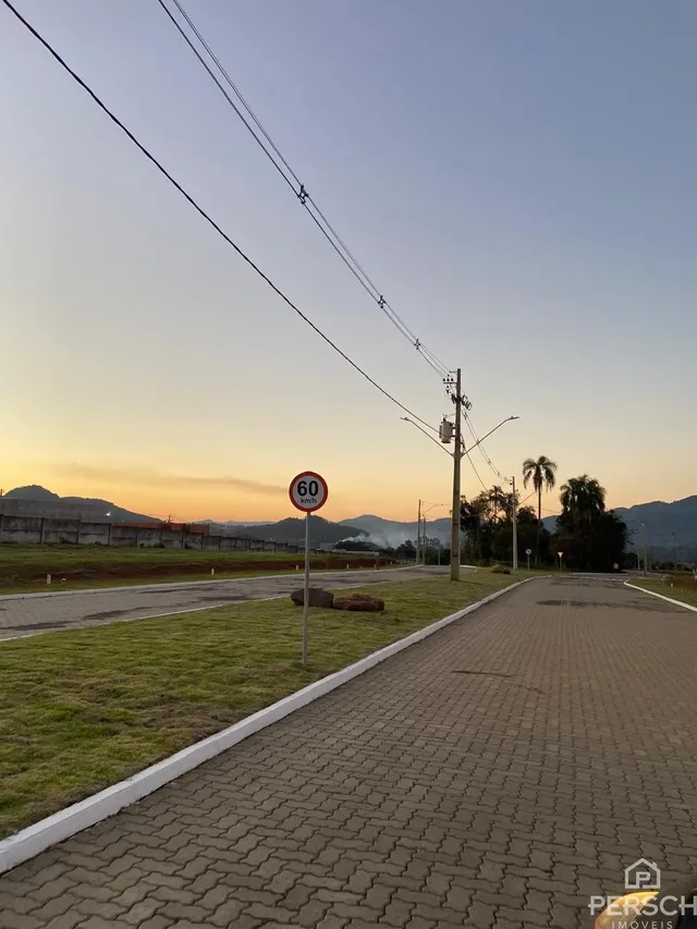 Vista da rua com sinal de limite de velocidade em Lajeado ao entardecer.