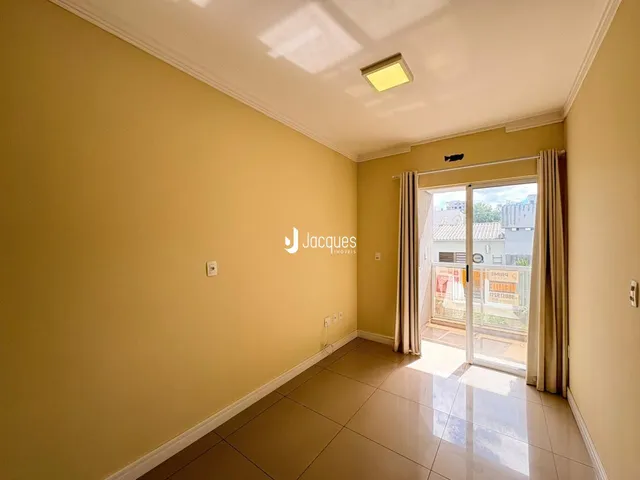 Foto de um corredor interno com paredes amarelas e piso de cerâmica.