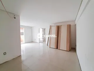 Hall de entrada com paredes brancas e piso claro.