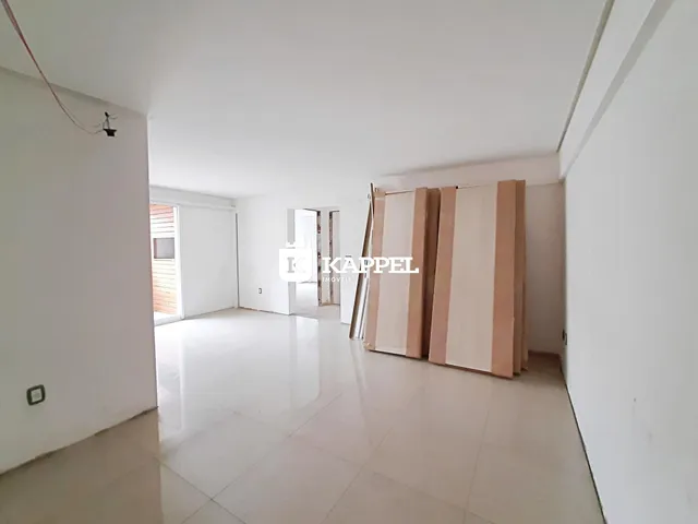Hall de entrada com paredes brancas e piso claro.