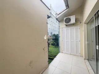 Vista da fachada de um imóvel em Lajeado, Brasil, mostrando um muro e uma porta de ferro.