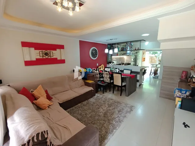 Sala de estar com sofá e parede vermelha em um imóvel em Lajeado.