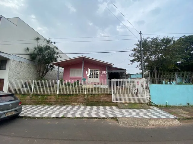 Fachada de uma residência em Lajeado, Brasil, com cerca branca.