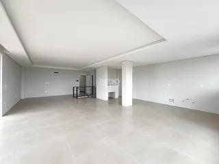 Sala ampla com piso de cerâmica clara e paredes brancas.