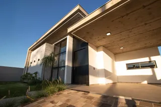 Fachada moderna de uma casa com grandes portas de vidro em Lajeado, Brasil.