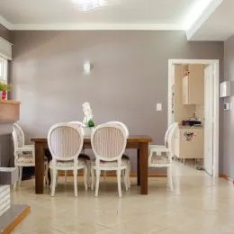 Ambiente interno com duas cadeiras de madeira em um espaço de jantar.