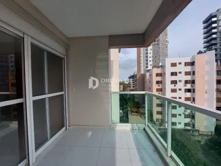 Vista de uma sala de estar com acesso a uma varanda com vista para edifícios.