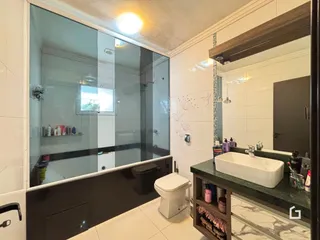 Foto de um banheiro moderno com box de vidro e revestimento branco.