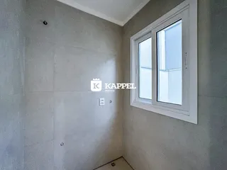 Parede interna de um cômodo com janela e acabamento em tom de cinza claro.