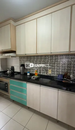 Cozinha moderna com armários brancos e bancadas escuras.