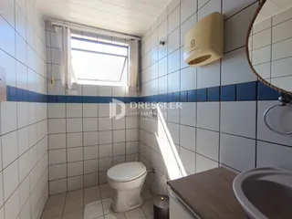 Foto de um banheiro com azulejos brancos e azuis.