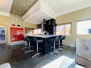 Foto da cozinha com ilha e banquetas em um imóvel no Brasil.