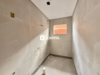 Foto de um corredor interno com paredes em fase de acabamento.