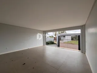 Vista interna de um ambiente amplo com paredes brancas e piso claro.