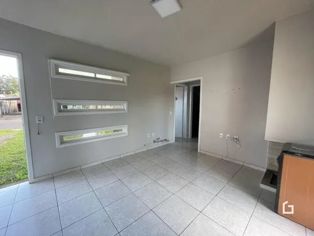 Imagem de uma área interna com piso de cerâmica e paredes brancas.
