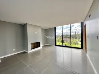 Sala de estar com grande janela e lareira em um imóvel em Lajeado.