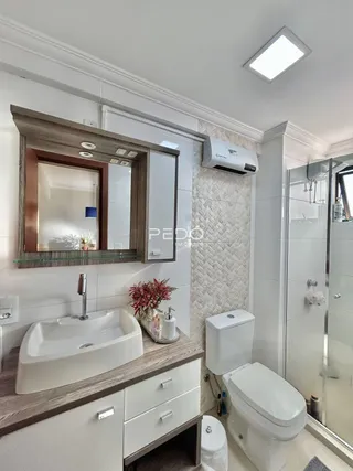 Foto do interior de um banheiro moderno com pia e vaso sanitário.