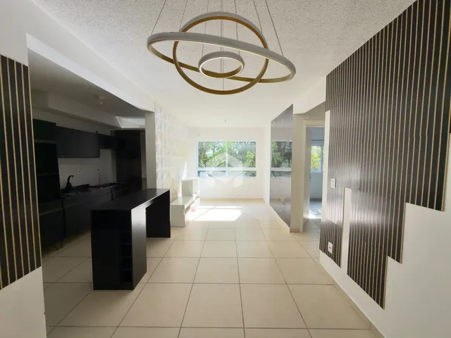 Sala de estar moderna com piso claro e iluminação central.