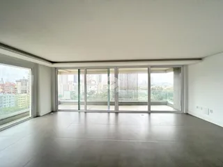 Sala de estar com vista para a cidade através de grandes janelas.