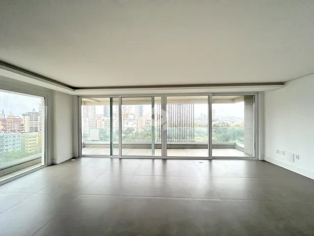 Sala de estar com vista para a cidade através de grandes janelas.