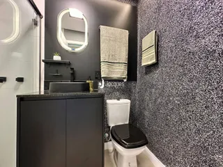 Banheiro moderno com revestimento texturizado e bancada escura.