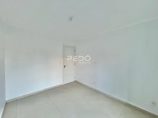 Vista interna de um cômodo vazio com piso claro e porta branca.