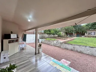 Vista de uma área externa com piso de cerâmica e jardim em Lajeado, Brasil.