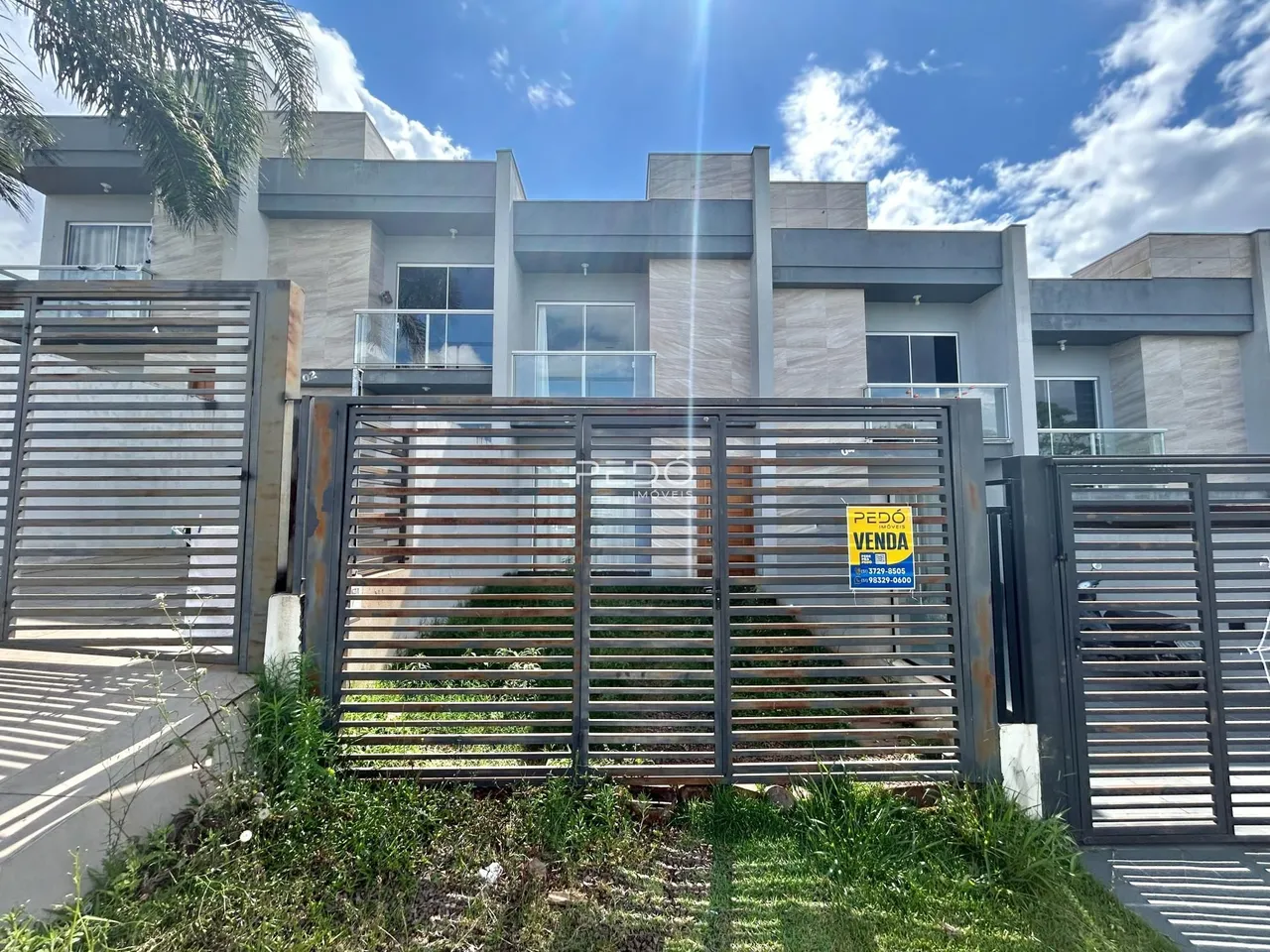 Fachada de uma residência moderna com portão de metal.