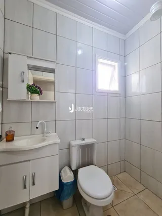 Foto de um banheiro com revestimento cerâmico e louças sanitárias.