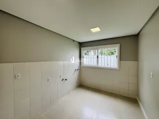 Corredor interno com paredes brancas e piso de cerâmica.