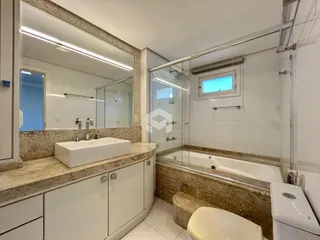 Imagem de um banheiro com banheira e box de vidro.