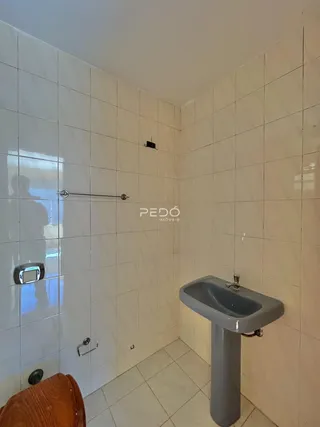 Foto de um banheiro com revestimento cerâmico branco.