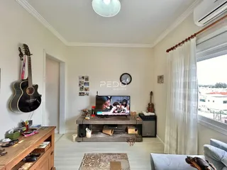 Sala de estar com piso de madeira e janela.