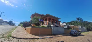 Fachada de uma residência em Lajeado, Brasil, com cerca e paisagem ao redor.
