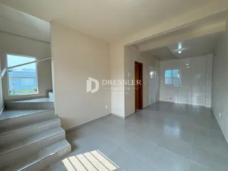 Hall de entrada com escadaria e piso de cerâmica em imóvel no Brasil.