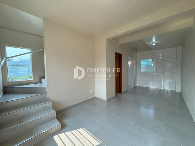 Hall de entrada com escadaria e piso de cerâmica em imóvel no Brasil.