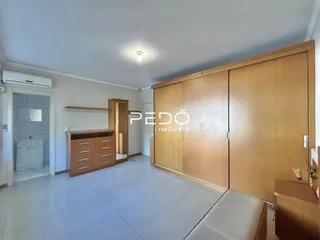Quarto com armários em madeira clara na residência.
