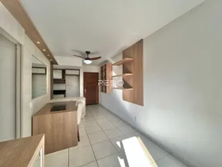 Vista interna de uma cozinha moderna com armários de madeira e piso cerâmico.