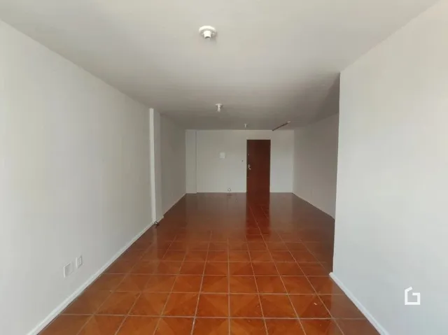 Corredor interno com piso de cerâmica marrom.