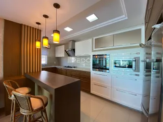 Foto de uma cozinha moderna com armários brancos e bancadas escuras.