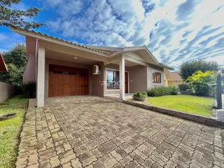 Fachada de uma casa em Lajeado, Brasil, com jardim e entrada pavimentada.