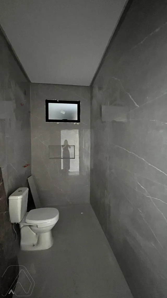 Foto de um corredor com um vaso sanitário em um ambiente interno.