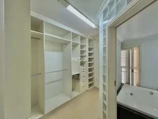 Hall de entrada com estantes embutidas brancas.