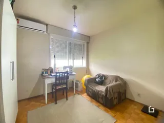 Uma sala de estar com piso de madeira e móveis.